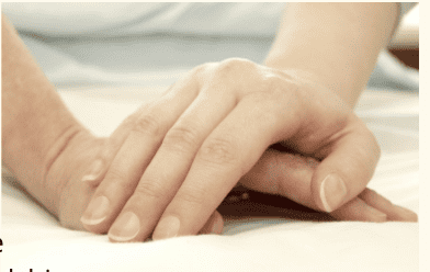 Two friends holding hands quietly, representing the healing power of friendship in grief.